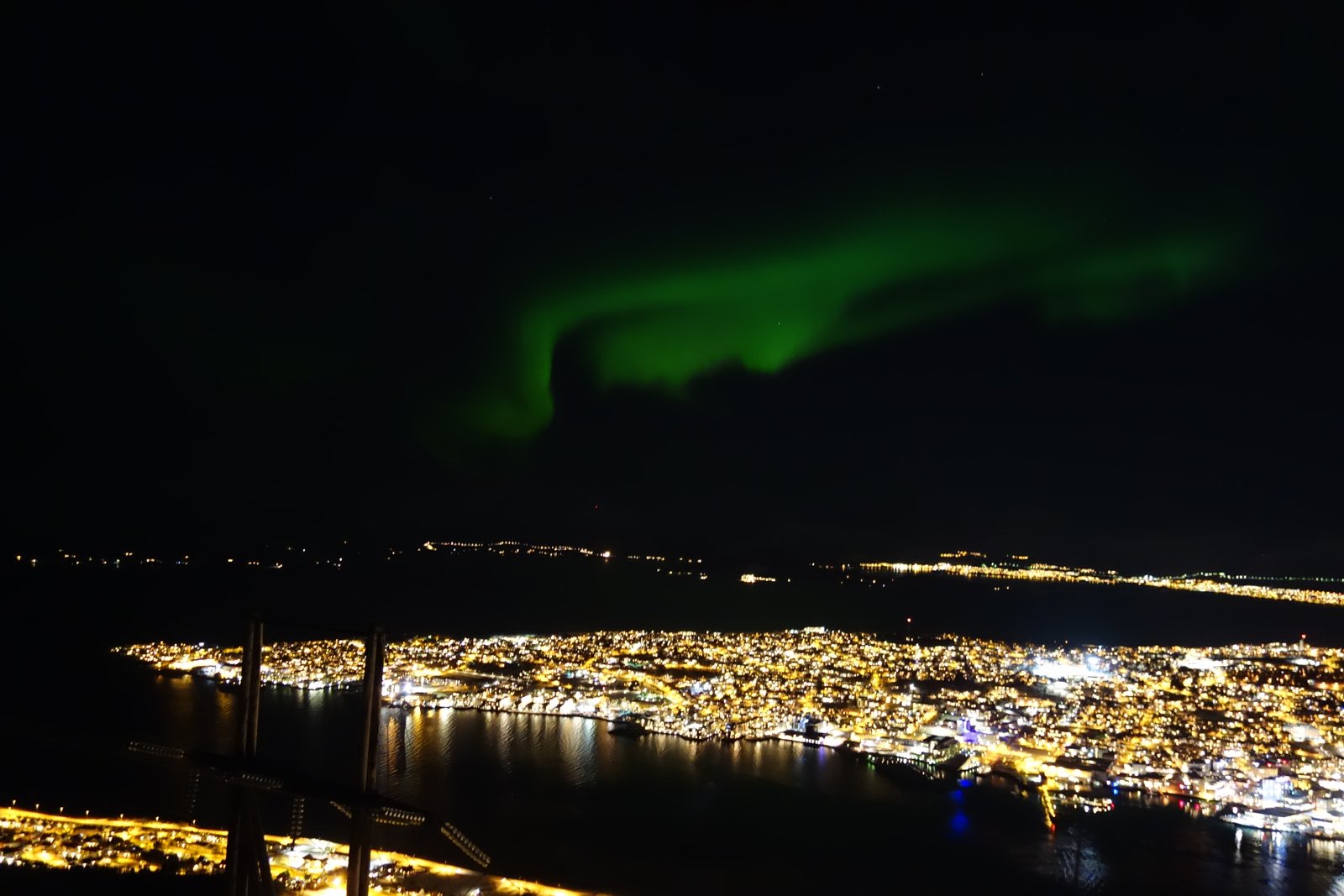 Early Northern Lights above Tromsø illuminated city